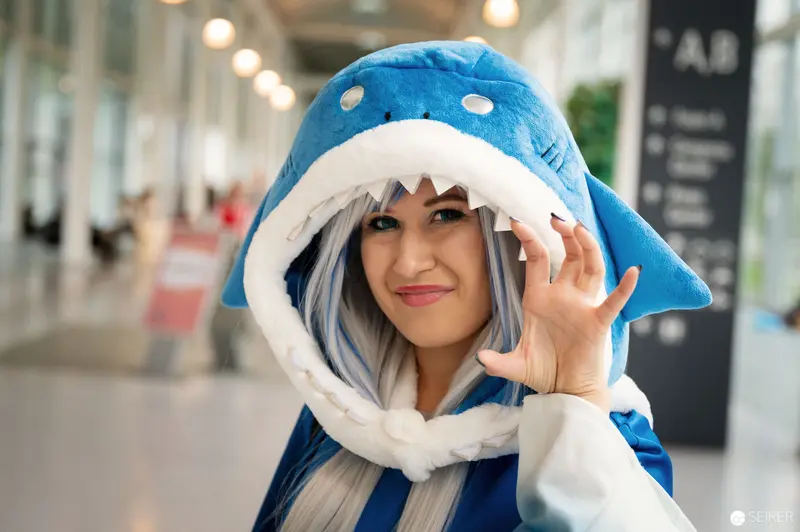 Blue Shark Cosplay at Vienna ComicCon 2022: Playful Pose in Shark Hat