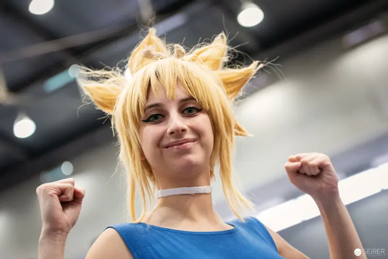 Cosplayer in Blonde Wig Striking Confident Pose at Vienna ComicCon