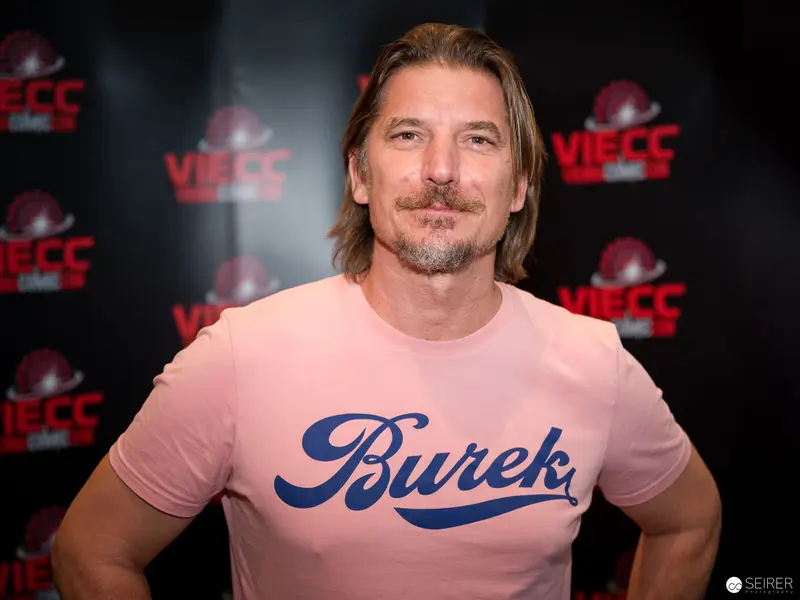 Burck-Branded Pink Shirt at Vienna ComicCon 2024 Event Backdrop