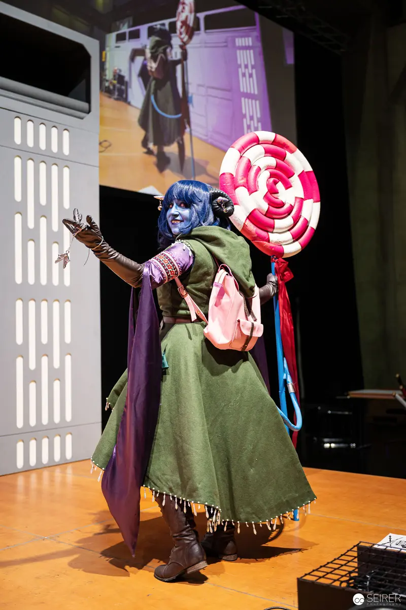 Blue-Haired Cosplayer in Green Dress Performing at Vienna ComicCon 2023