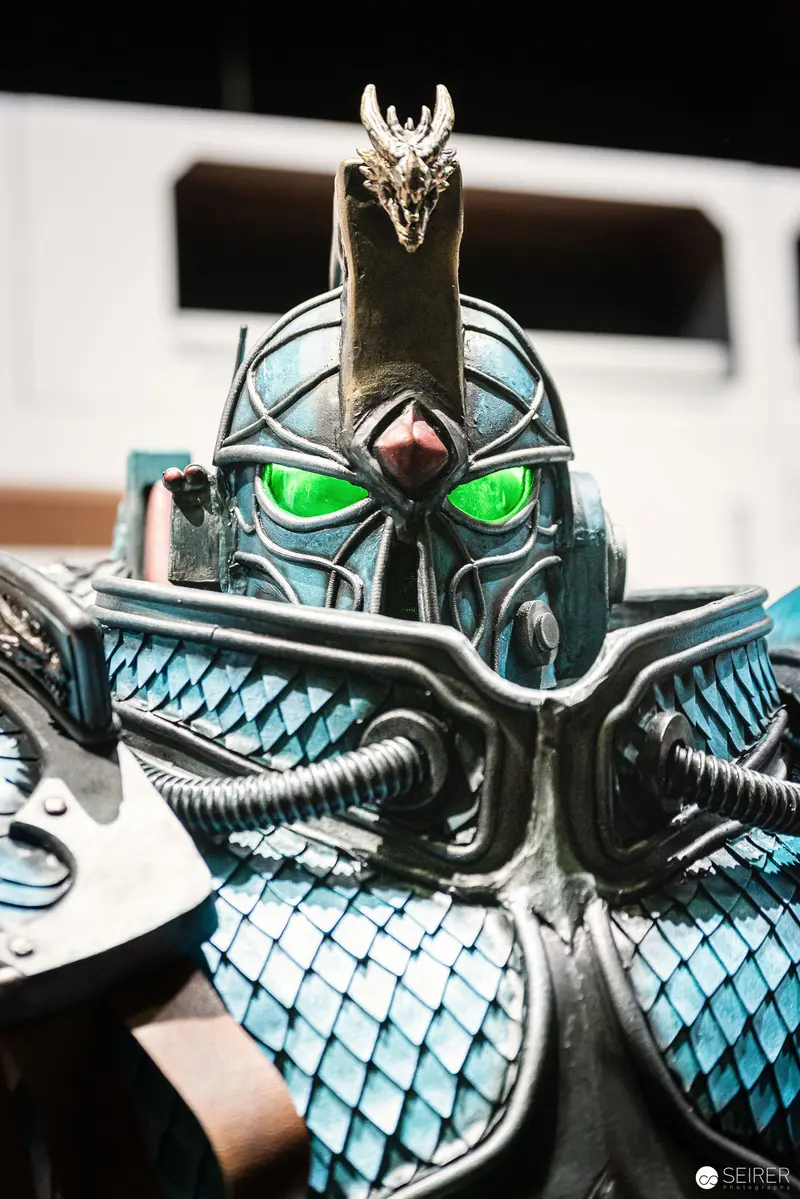 Intricately Detailed Armored Knight Cosplay with Glowing Green Helmet at Comic Convention