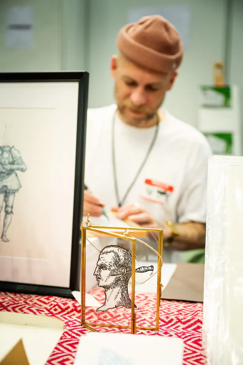 Artist Sketching Profile Portrait at Vienna ComicCon Drawing Station