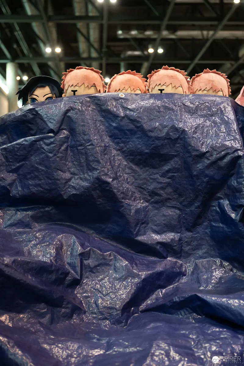 Cosplayers Huddled Under Blue Tarp at Vienna ComicCon 2023