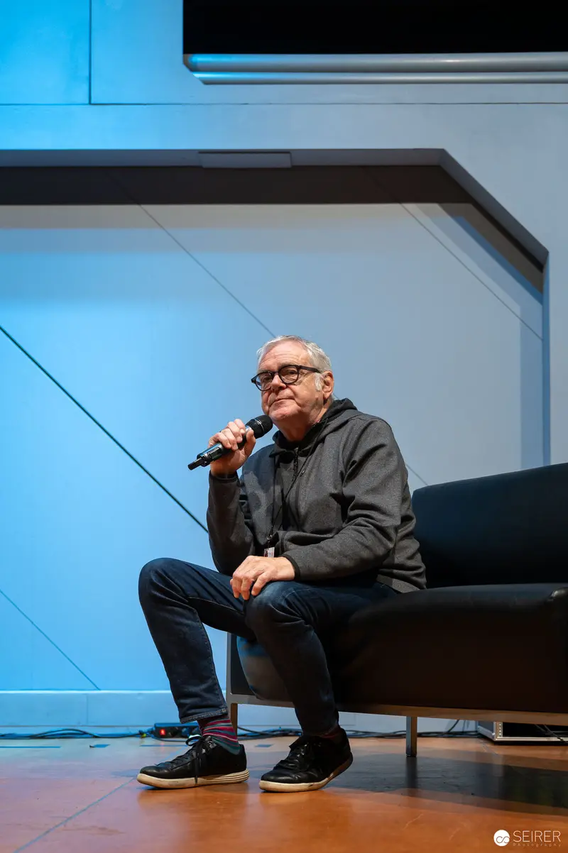 Veteran Speaker at Vienna ComicCon 2022, Seated on Stage with Microphone