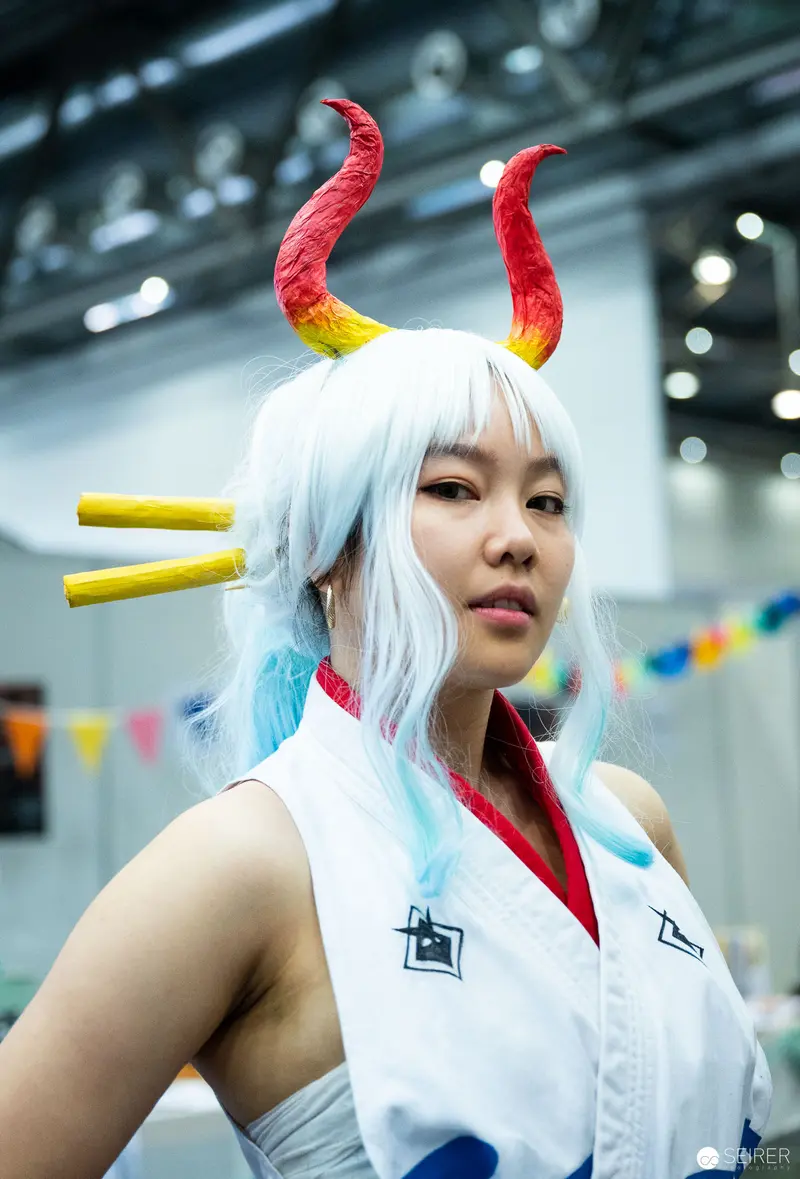 Cosplayer with Red and Yellow Horns at Vienna ComicCon 2023