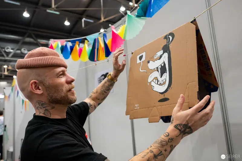 Artist Mounting Cartoon Artwork at Vienna ComicCon 2022 Comic Festival