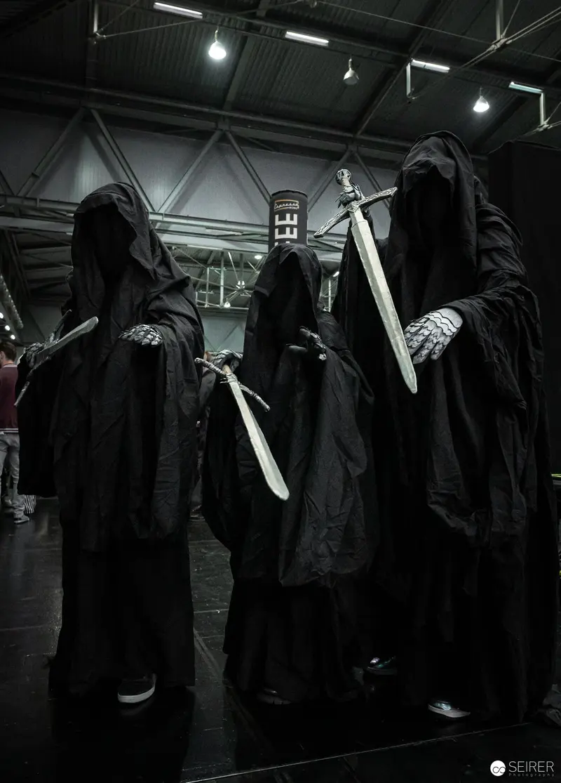 Hooded Figures with Swords at Dark Cosplay Convention Venue