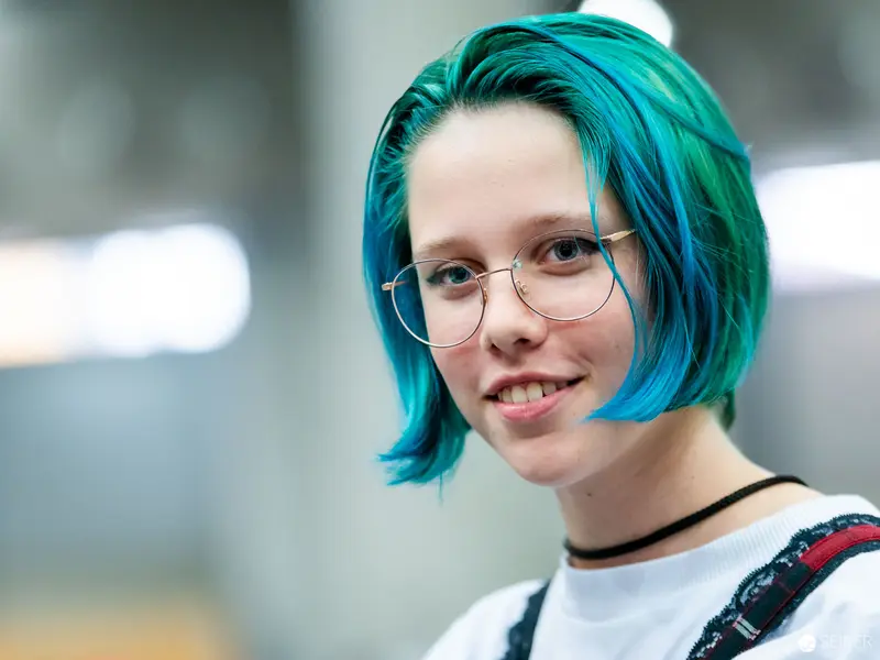 Teal-Haired Attendee at Vienna ComicCon 2022 Wearing Round Glasses