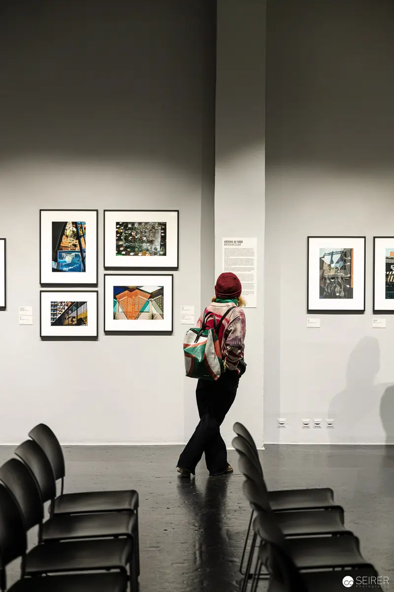 Solitary Gallery Visitor Examining Framed Artwork in Minimalist Exhibition Space