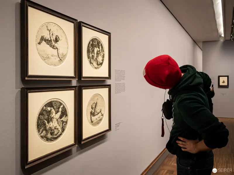 Viewer in Red Cap Examining Circular Prints at Dürer Exhibition, Albertina Vienna