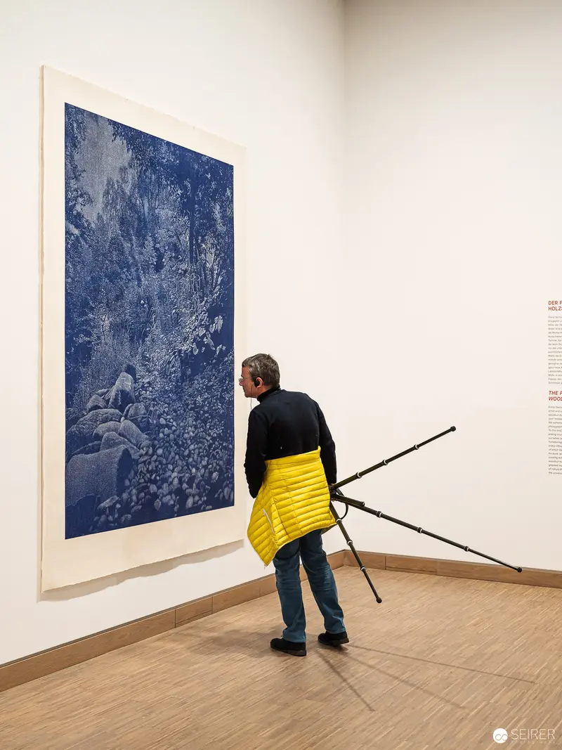 Visitor Examining Blue Artwork at "Andy Warhol bis Damien Hirst" Exhibition, Albertina Modern
