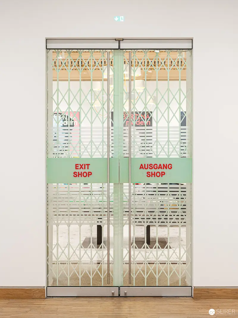 Exit and Ausgang Shop Sliding Doors in Minimalist Interior Setting