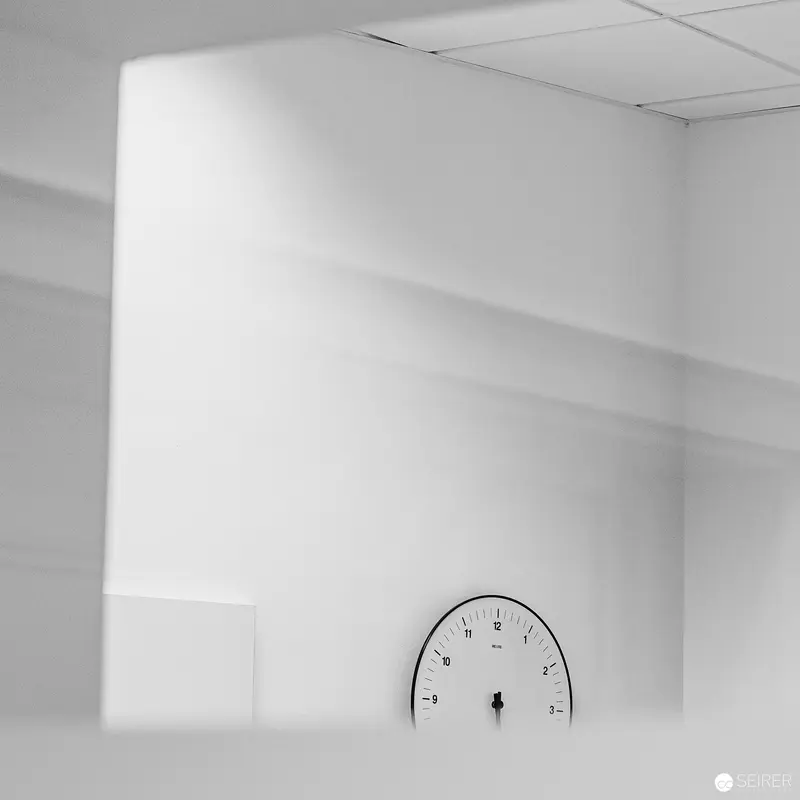 Minimalist Interior with Wall Clock at Webster University Vienna