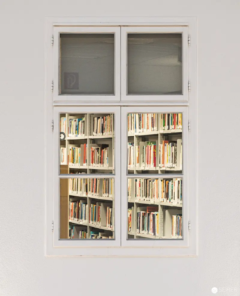 White-Framed Bookcase Vitrine Displaying Densely Arranged Academic Library Collection