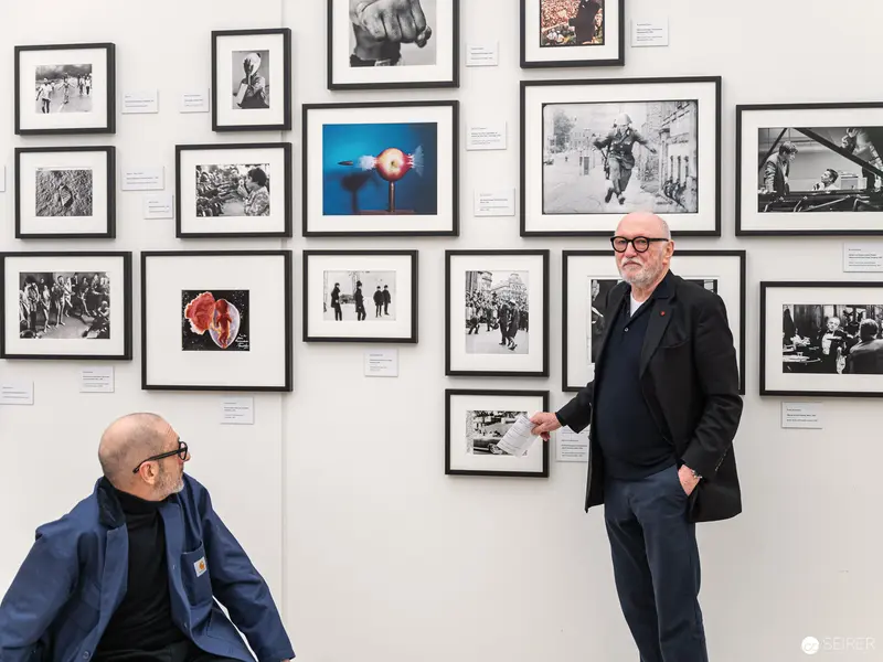 Art Gallery Curators Discussing Photographic Exhibition Wall Arrangement