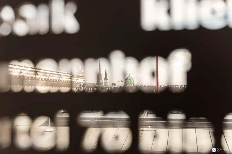 Blurred Vienna Cityscape Through Perforated Architectural Lens