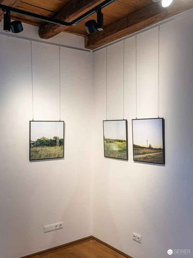 Landscape Photographs Displayed in Minimalist Gallery Corner Setting