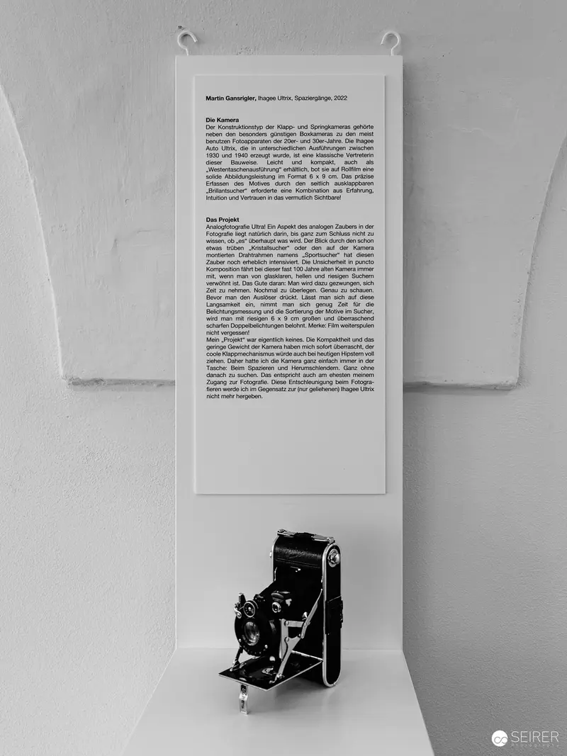 Vintage Folding Camera Displayed with Descriptive Exhibit Panel in Monochrome