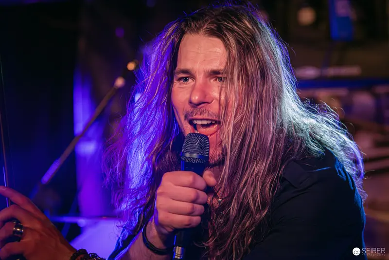 Passionate Lead Singer Performing at Replugged Vienna with Intense Purple Lighting