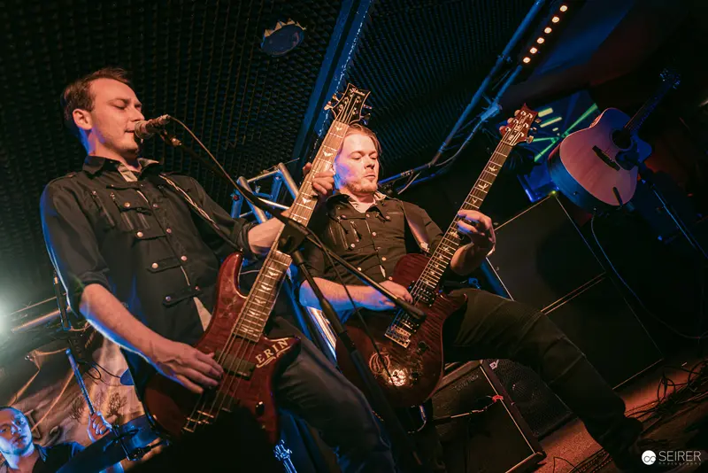 Dual Guitarists Performing Intense Rock Set at Replugged Vienna