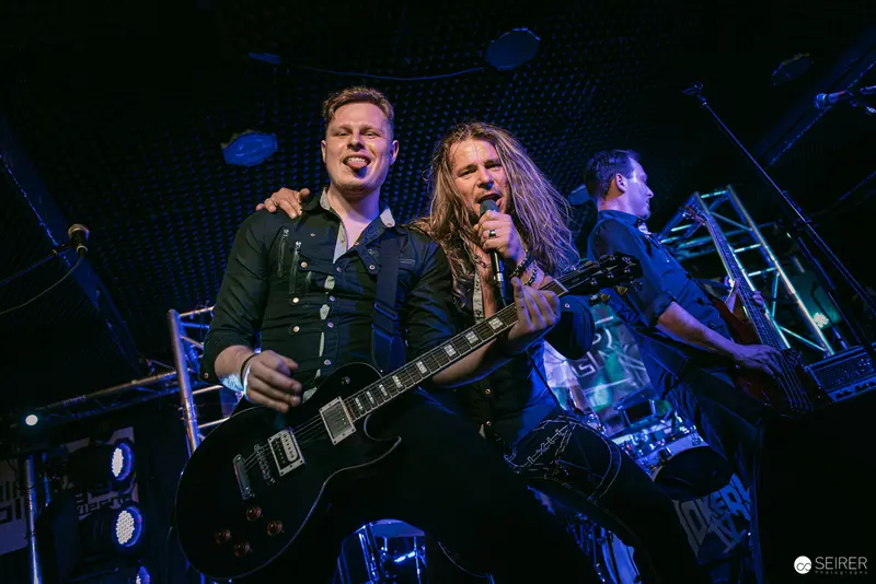 Erin at Replugged Vienna: Electric Rock Performance Under Blue Stage Lights