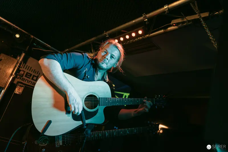 Erin Performing Acoustic Set at Replugged Vienna with Intense Musical Expression