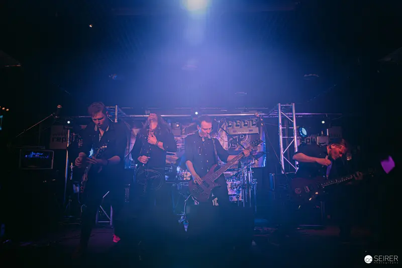 Replugged Band Performing Under Intense Blue Stage Lighting in Vienna