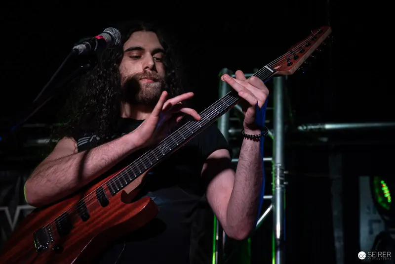 Extreme Mind Guitarist Performing Intense Solo at Replugged Concert