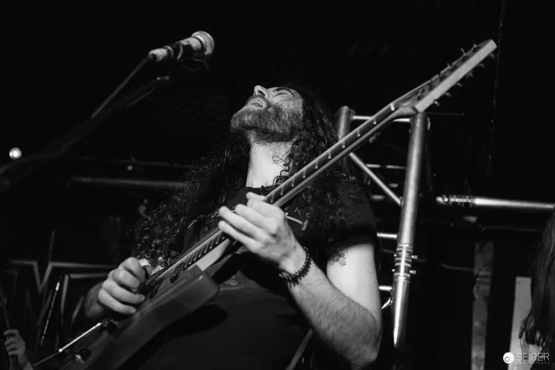 Extreme Mind Guitarist Performing Intensely at Replugged Concert in Black and White