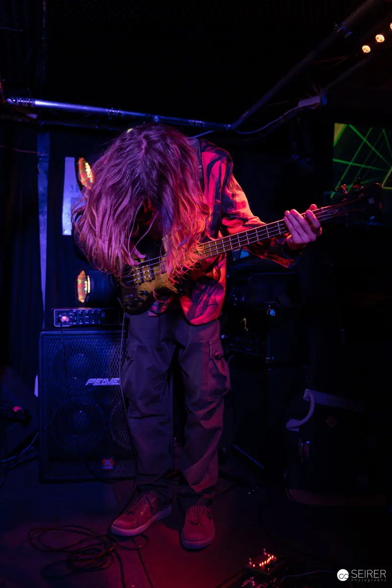 Extreme Mind Bassist Performing Under Vibrant Stage Lighting at Replugged
