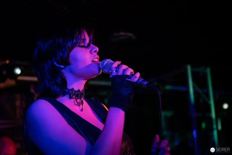 Extreme Mind Vocalist Performing in Vibrant Blue and Purple Stage Lighting at Replugged