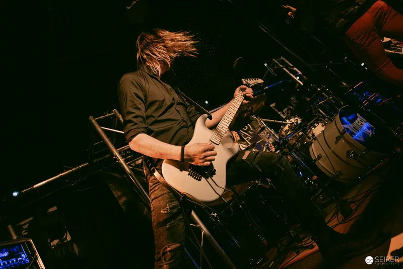 Jokers IV Guitarist Performs Dynamically at Replugged, Vienna with Hair in Motion