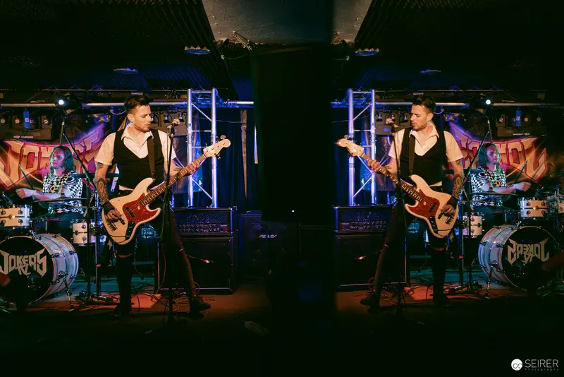 Jokers IV Bassist Performing at Replugged in Dramatic Blue Stage Lighting