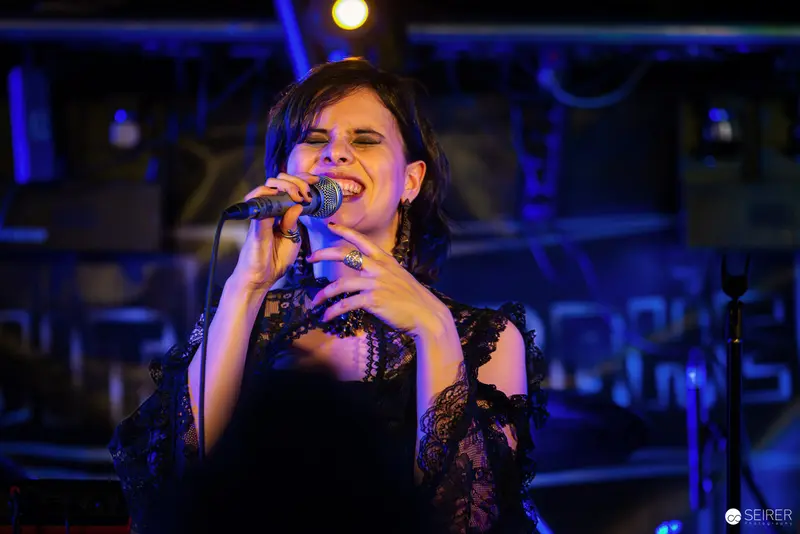 Nightmarcher Vocalist Performing Passionately at Replugged Vienna with Dramatic Blue Lighting