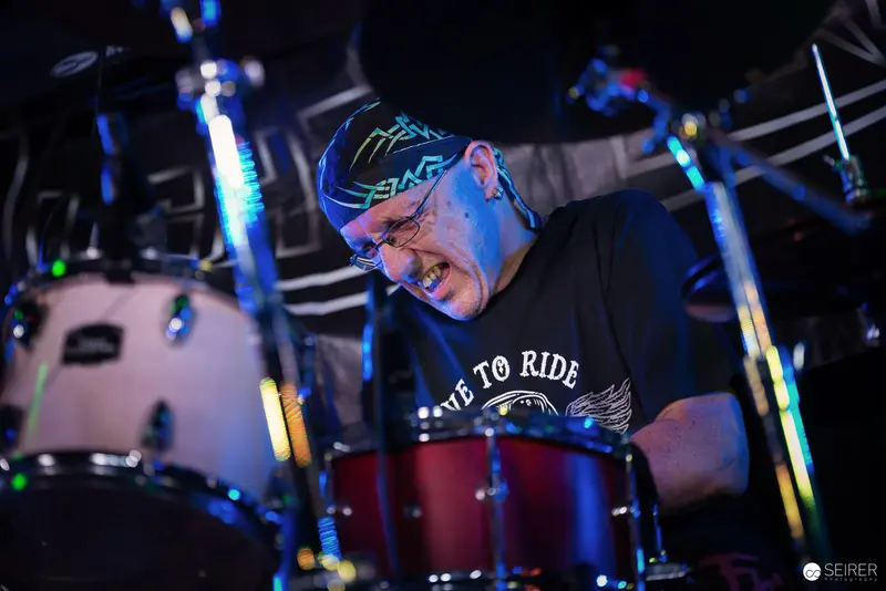 Nightmarcher Drummer Performing Intensely at Replugged Vienna Under Blue Stage Lights