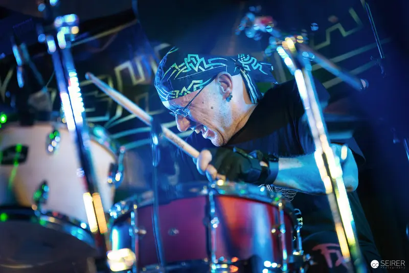 Nightmarcher Drummer Intensely Performing Under Dynamic Blue Stage Lighting at Replugged Vienna