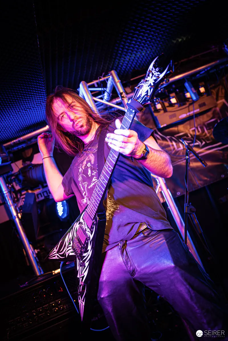 Nightmarcher Guitarist Performing Intensely at Replugged Vienna with Dramatic Stage Lighting