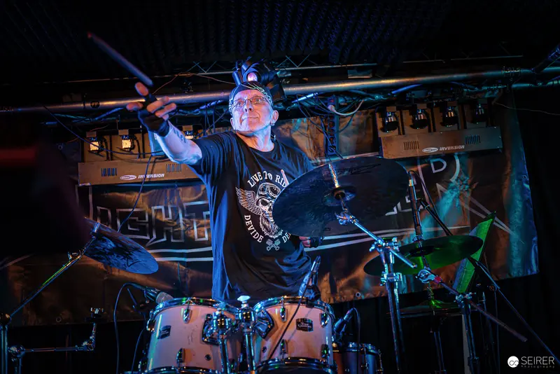 Nightmarcher Drummer Performing Intensely Under Dynamic Stage Lighting at Replugged Vienna