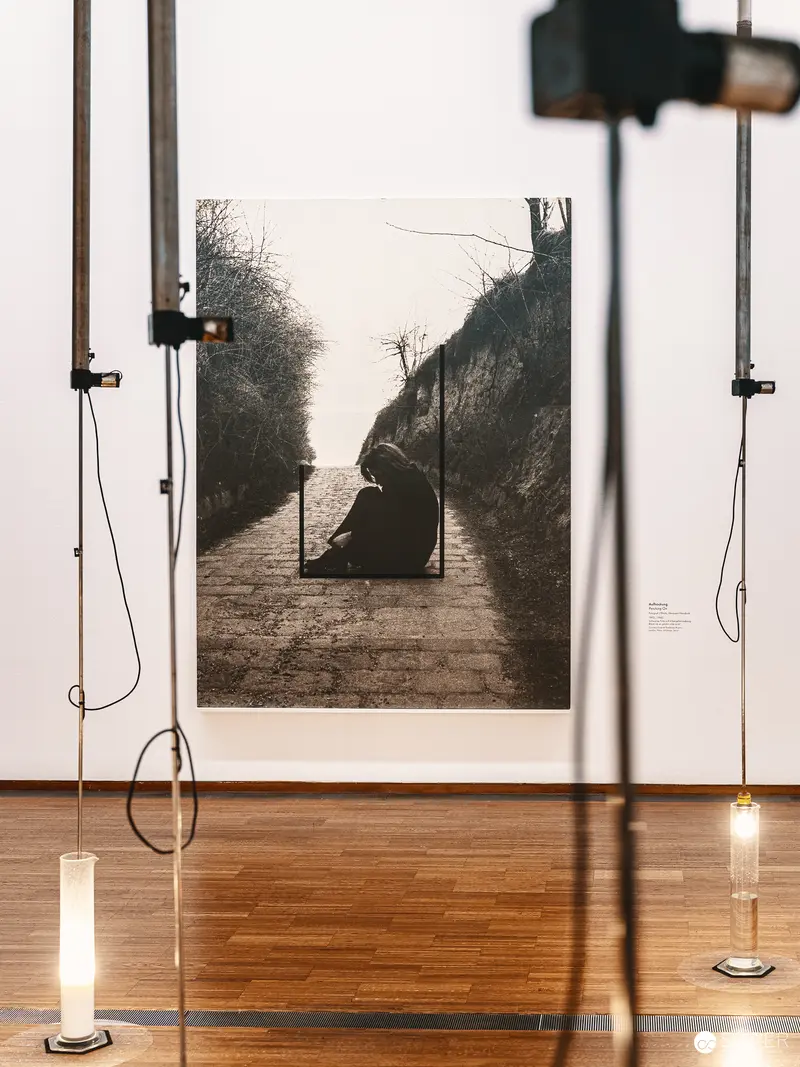 Contemplative Figure on Dimly Lit Path: Photographic Installation at Gallery Exhibition