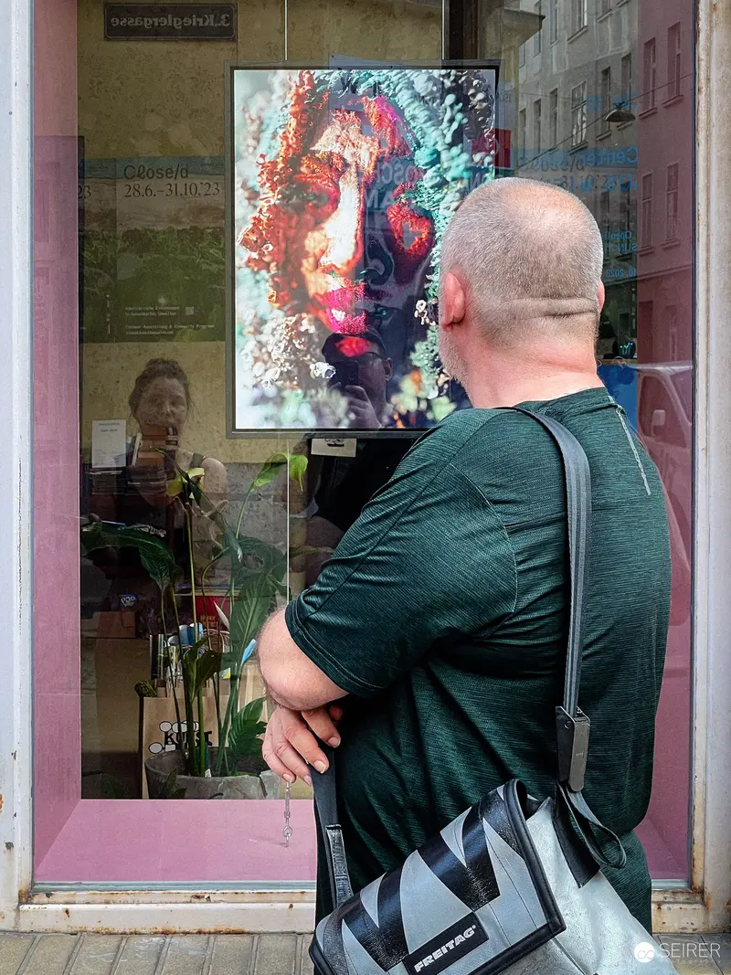 Contemplative Viewer Examining Vibrant Portrait at Gallery Window
