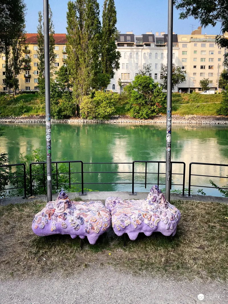 Purple Egg-Shaped Sculptures Beside Urban Waterway in Vienna
