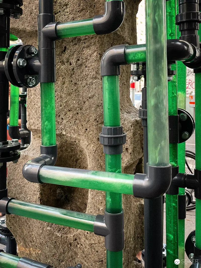 Industrial Green and Gray Pipe Network on Textured Wall Surface