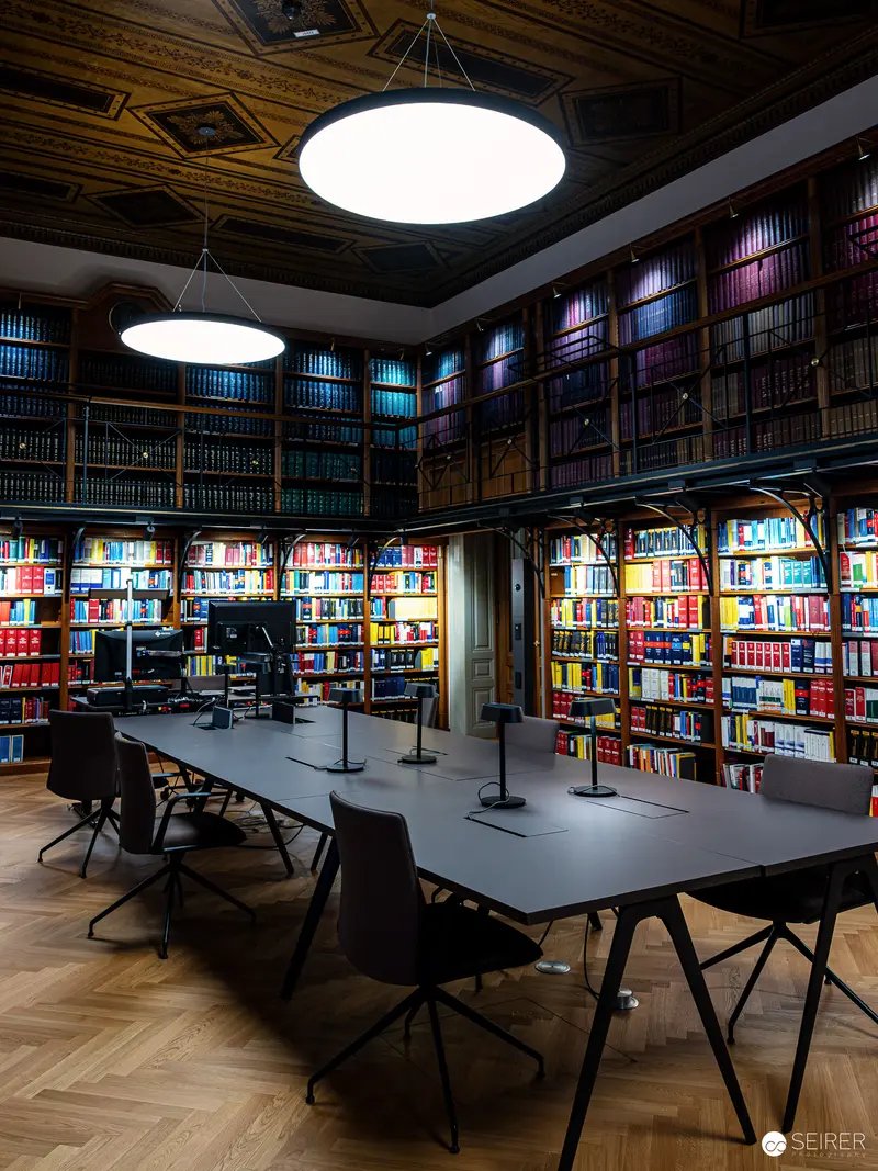 Modern Academic Library Interior with Illuminated Bookshelves and Study Tables