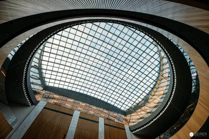 Architectural Interior with Geometric Glass Dome and Curved Wooden Paneling