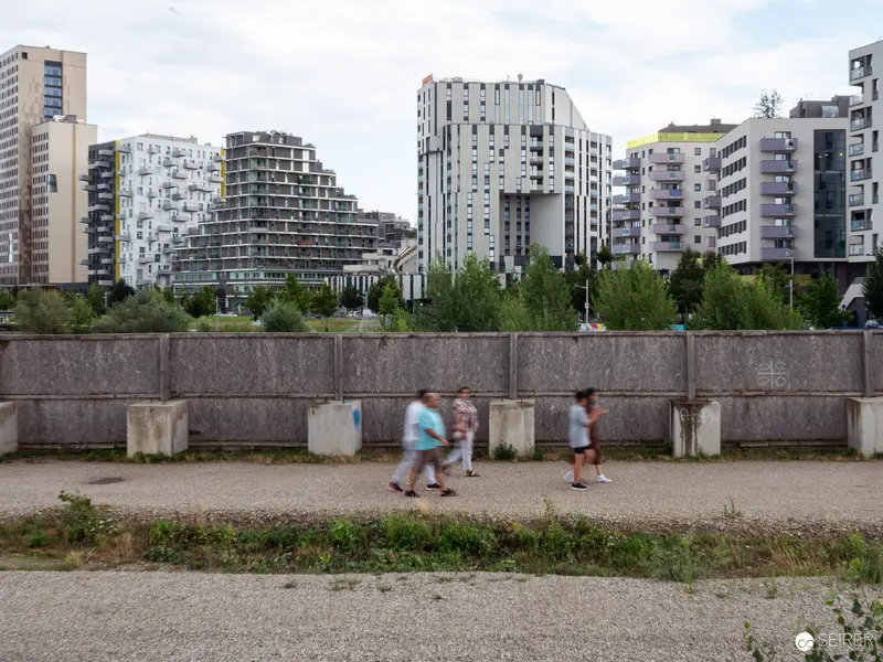 Urban Landscape with Blurred Pedestrians along Concrete Wall in Modern District