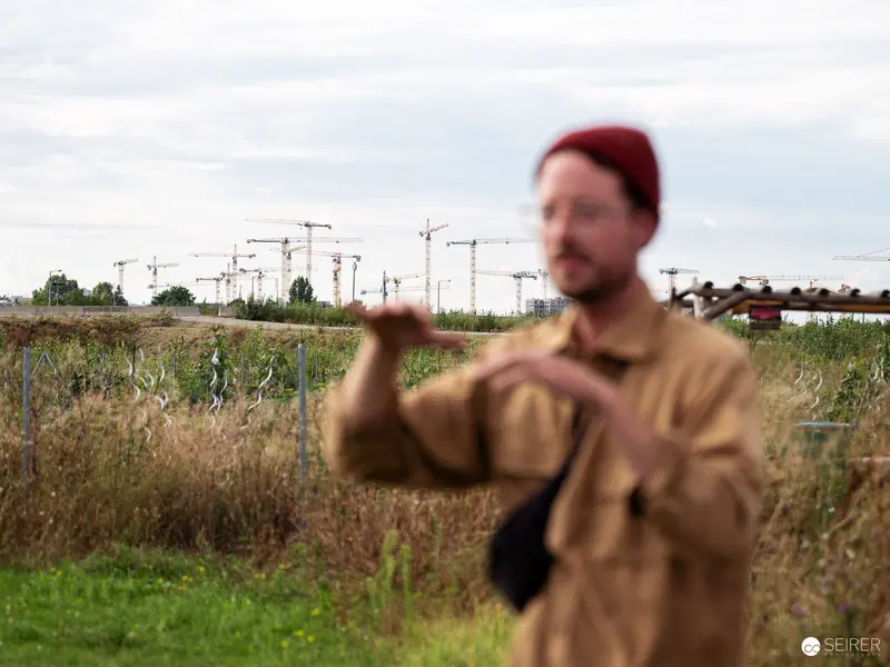 Urban Agricultural Landscape with Construction Cranes and Contemplative Observer