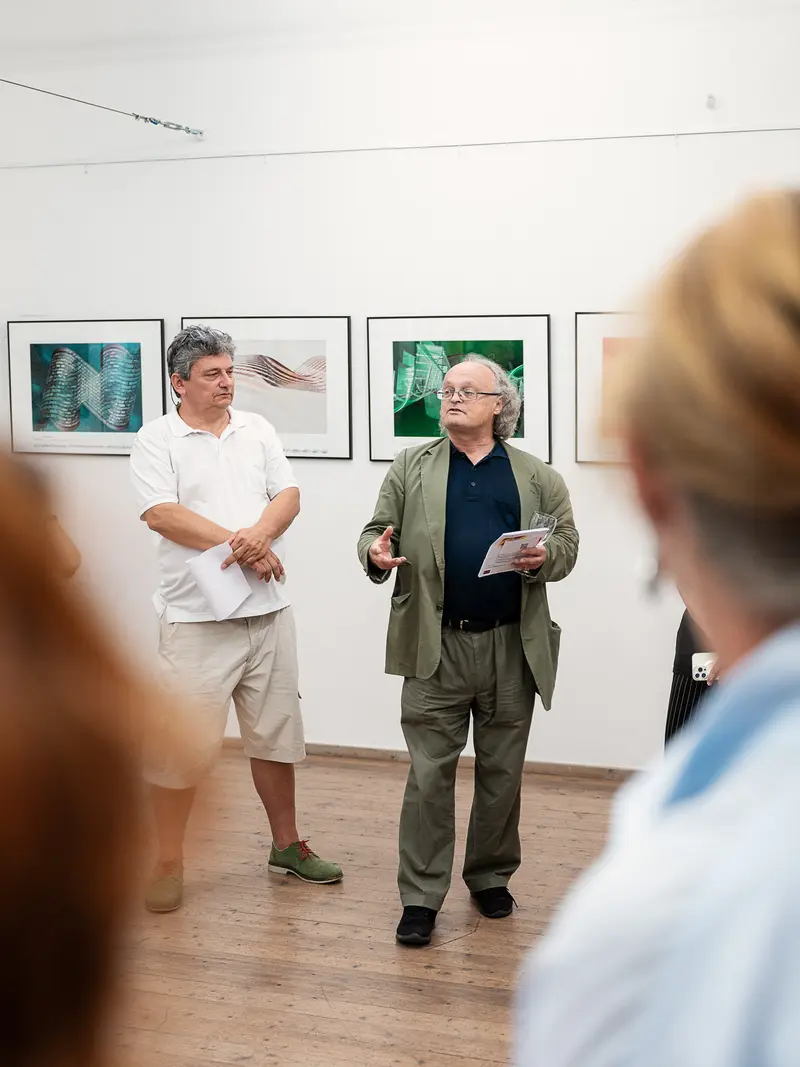 Art Gallery Curator and Visitor Discussing Photographic Exhibition