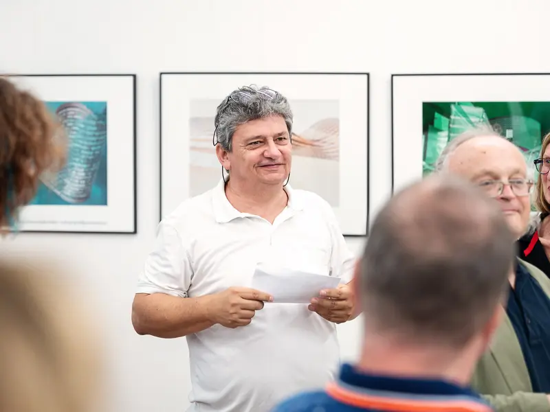 Gallery Exhibition Curator Presenting Artwork in White Polo Shirt