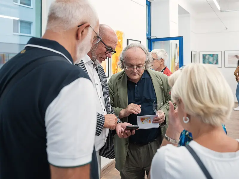 Mature Visitors Examining Artwork at Gallery Exhibition