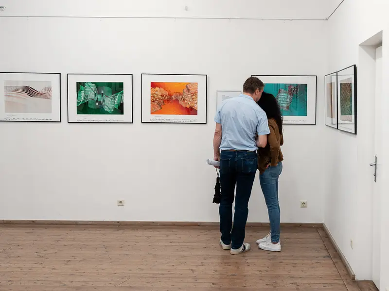 Two Gallery Visitors Studying Contemporary Photographic Exhibition